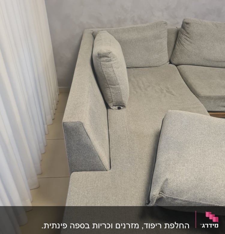 כריות ריפוד אפורות על ספה פינתית